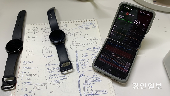 김은희(가명·40대 초반)씨와 1형 당뇨를 앓고 있는 아들 준서(가명·12)가 사용하는 스마트 워치와 핸드폰 속 혈당 차트. 주사요법을 사용할 때 사용한 ‘r’, ‘n’을 기록한 공책이 뒤편에 놓여 있다. 2024.4.27 /유혜연기자 pi@kyeongin.com